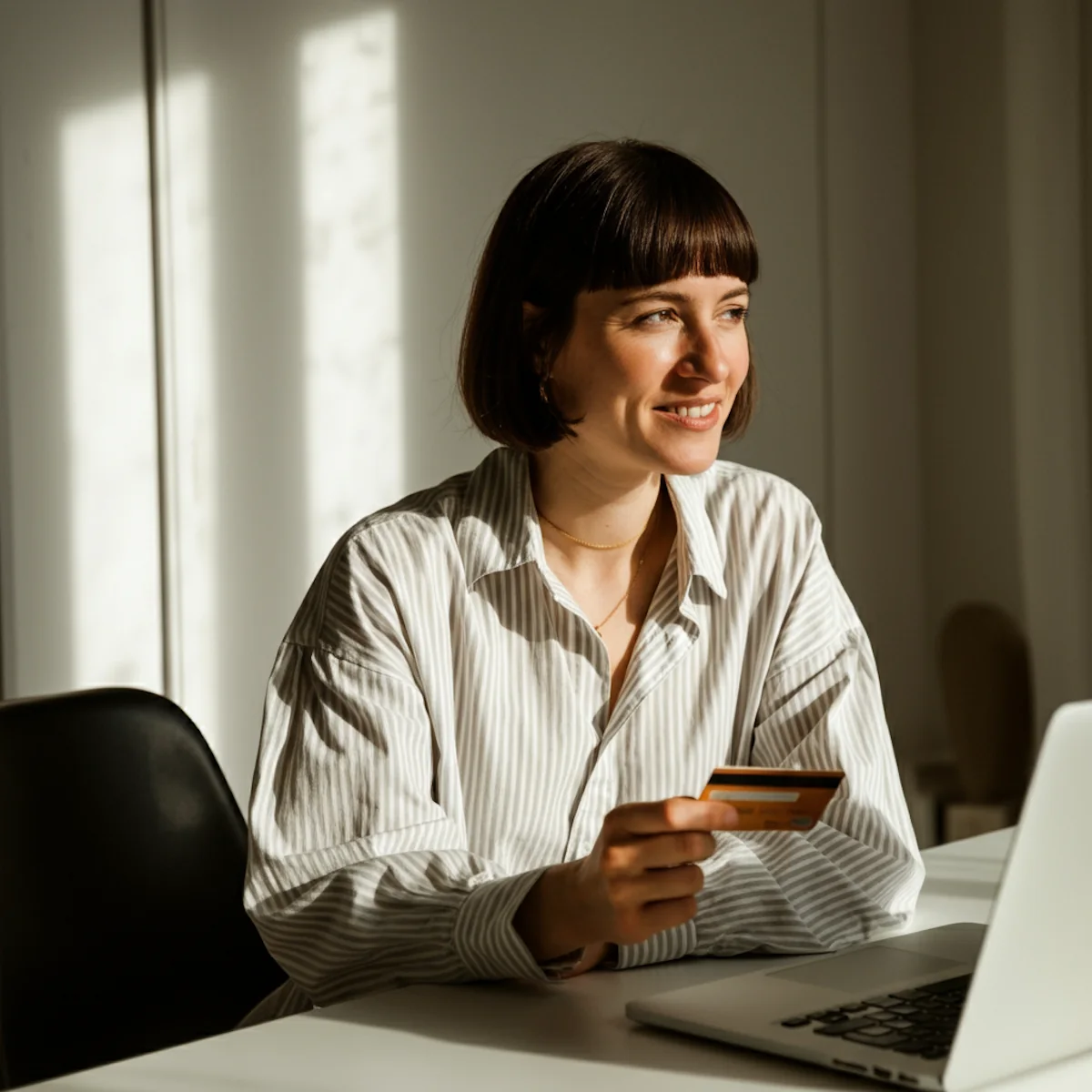Customer at a laptop holding a payment card